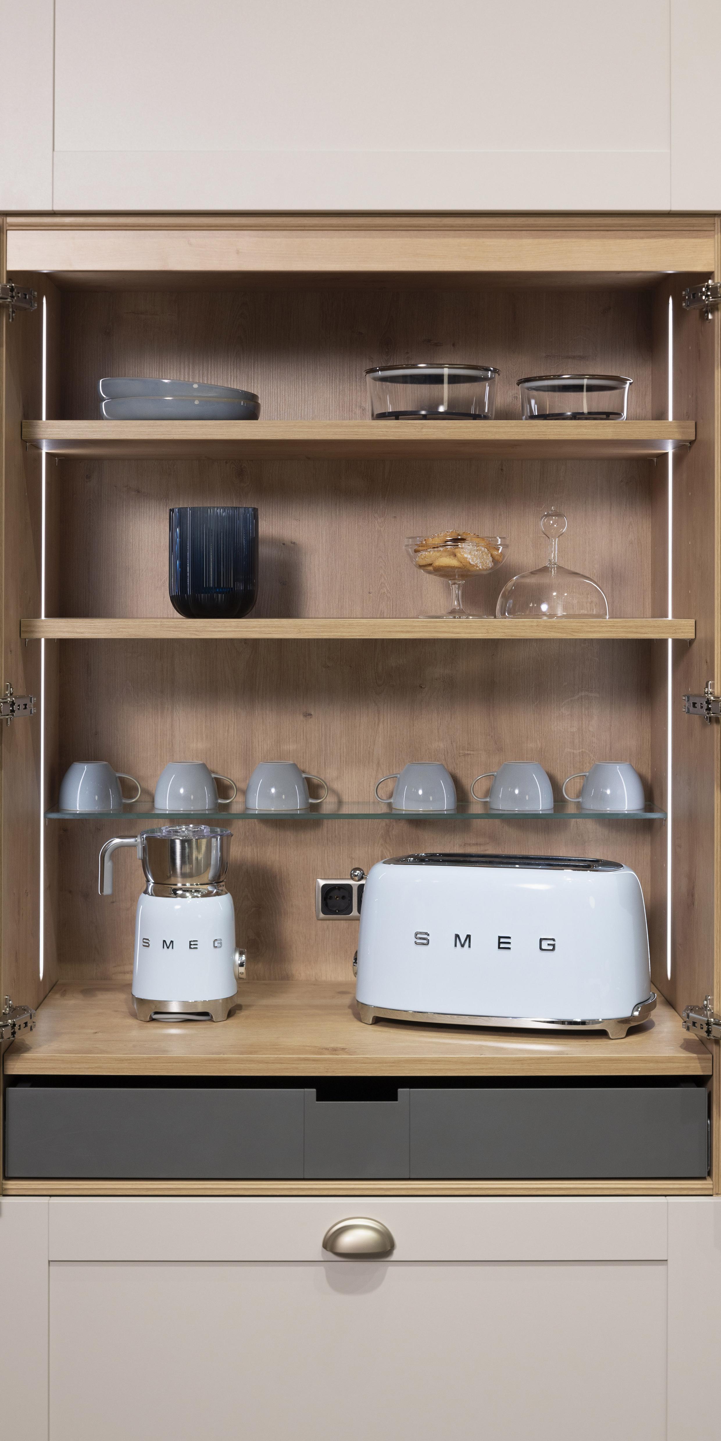 Offener Küchenschrank mit Toaster, Kaffeemaschine, Tassen und Gläsern auf Regalen.